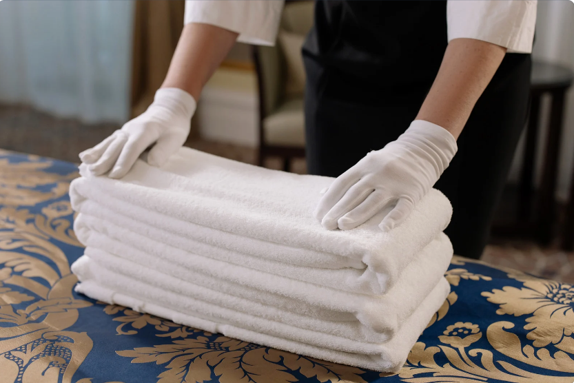 Hotel staff placing clean Sanitation Towels in guestroom.