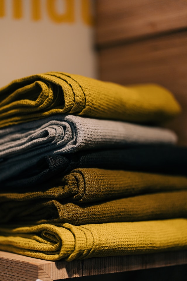 A folded pile of mustard colored and grey linen towels